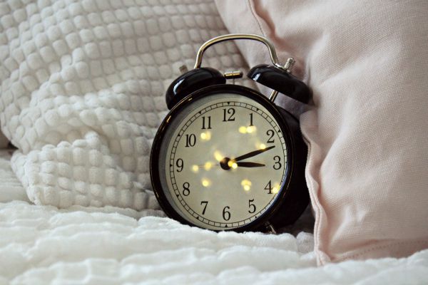 black alarm clock on bed | 7 Science-Backed Secrets of a Productive Morning Routine  https://positiveroutines.com/productive-morning-routine/