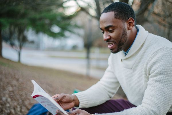  man reading outdoors | Why is Nature Important to Happiness  https://positiveroutines.com/why-is-nature-important-happiness/
