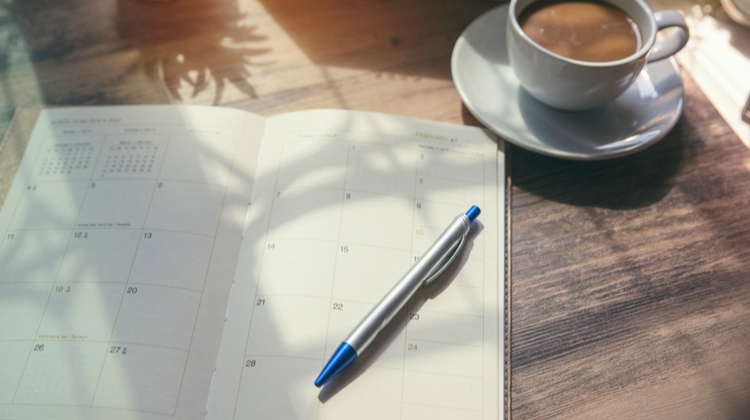 open calendar planner beside cup of coffee | The Best Productivity Planners for a Stress-Free Schedule https://positiveroutines.com/best-productivity-planners/