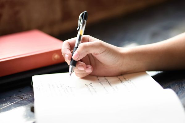 person writing notes in journal | 7 Science-Backed Secrets of a Productive Morning Routine  https://positiveroutines.com/productive-morning-routine/