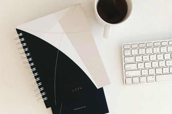 planners beside keyboard and cup of tea | How to Stop Feeling Guilty For Not Getting "Enough" Work Done https://positiveroutines.com/stop-feeling-guilty/