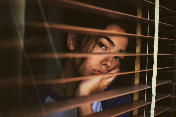 exhausted woman looking out window | 3 Ways Being Too Busy Hurts Your Productivity https://positiveroutines.com/too-busy-productivity/
