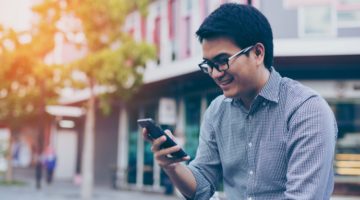 happy man using smartphone | 8 Gratitude Apps to Boost Your Happiness Now https://positiveroutines.com/gratitude-apps/