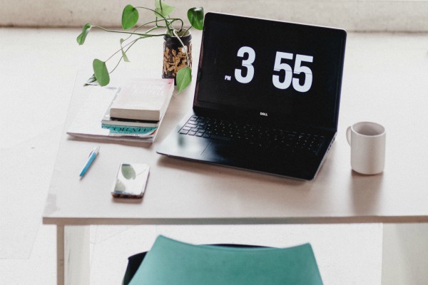 clean workstation with time displayed on laptop | Why You Don't Need a Time-Management Plan  https://positiveroutines.com/time-management-plan/