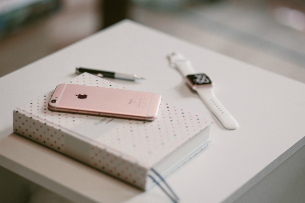 iPhone watch and notebook set aside on table | Why You Don't Need a Time-Management Plan  https://positiveroutines.com/time-management-plan/
