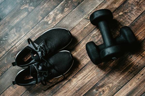 sneakers and dumbbells on wood floor | Why Does Exercise Make You Happy  https://positiveroutines.com/why-does-exercise-make-you-happy/