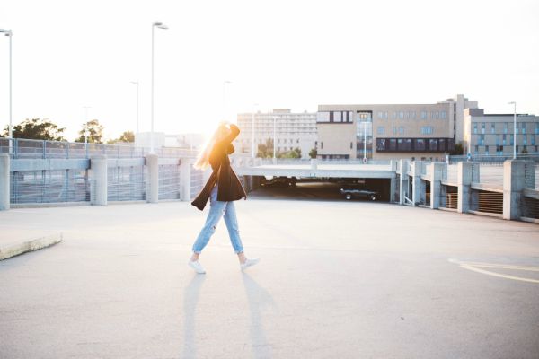 woman walking around parking lot | Why Does Exercise Make You Happy  https://positiveroutines.com/why-does-exercise-make-you-happy/