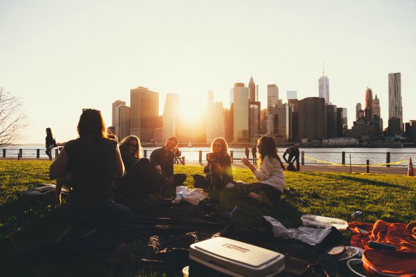 friends picnicking in park | 7 Things to Do on the Fourth of July That Will Make You Happier https://positiveroutines.com/things-to-do-on-fourth-of-july/