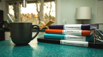 stack of planners beside coffee mug | https://positiveroutines.com/back-to-school-planner-guide/