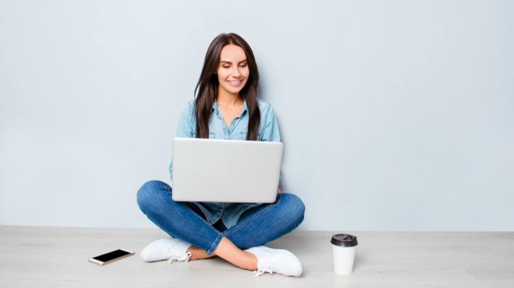young woman sitting with laptop and mobile phone | 7 Note-Taking Apps for Your Best Academic Year Yet https://positiveroutines.com/note-taking-apps/