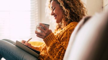 cozy woman writing in journal and enjoying tea | 73 Ways to Make Your Goals and Dreams Happen This Fall https://positiveroutines.com/goals-and-dreams/