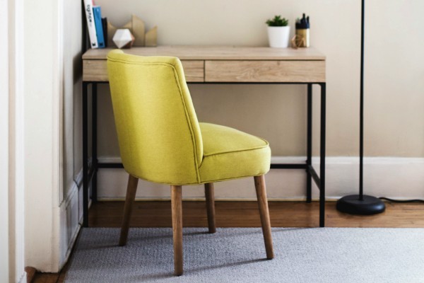 green chair in home office | 7 Easy Ways to Create a Healthy Work Environment https://positiveroutines.com/work-environment-tips/