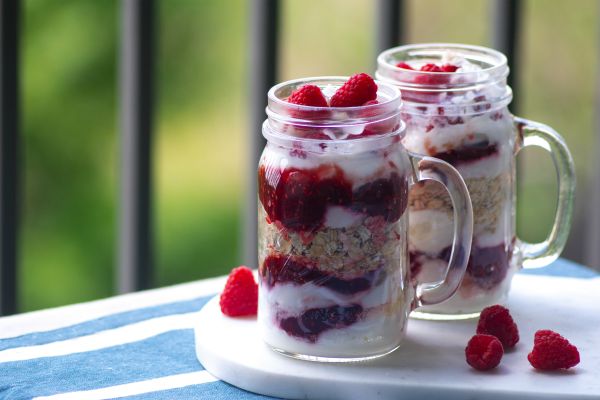mason jars full of yogurt oats and berries | 7 Natural Ways to Boost Energy, According to Science https://positiveroutines.com/natural-ways-to-boost-energy/