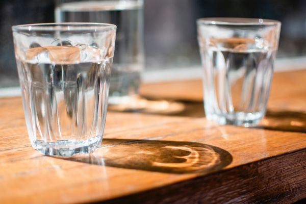two glasses of water | 7 Natural Ways to Boost Energy, According to Science https://positiveroutines.com/natural-ways-to-boost-energy/