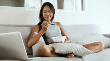 woman on couch enjoying breakfast looking at laptop | A Simple Morning Ritual for a New School Year https://positiveroutines.com/simple-morning-ritual/