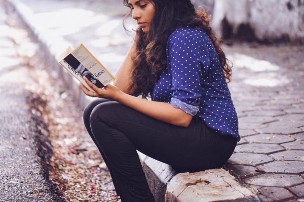 woman reading book on sidewalk | How to Concentrate in a Digitally Distracting World https://positiveroutines.com/how-to-concentrate/