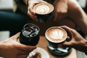 three friends cheers with coffee drinks | Why Making Friends at Work Matters and How To Do It https://positiveroutines.com/making-friends-at-work/