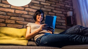 happy woman reading book in evening | The Happiness-Boosting Magic of Evening Routines https://positiveroutines.com/evening-routines/